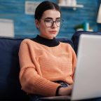 programmer-with-glasses-holding-laptop-on-sofa-wri-2022-01-04-23-27-39-utc.jpg